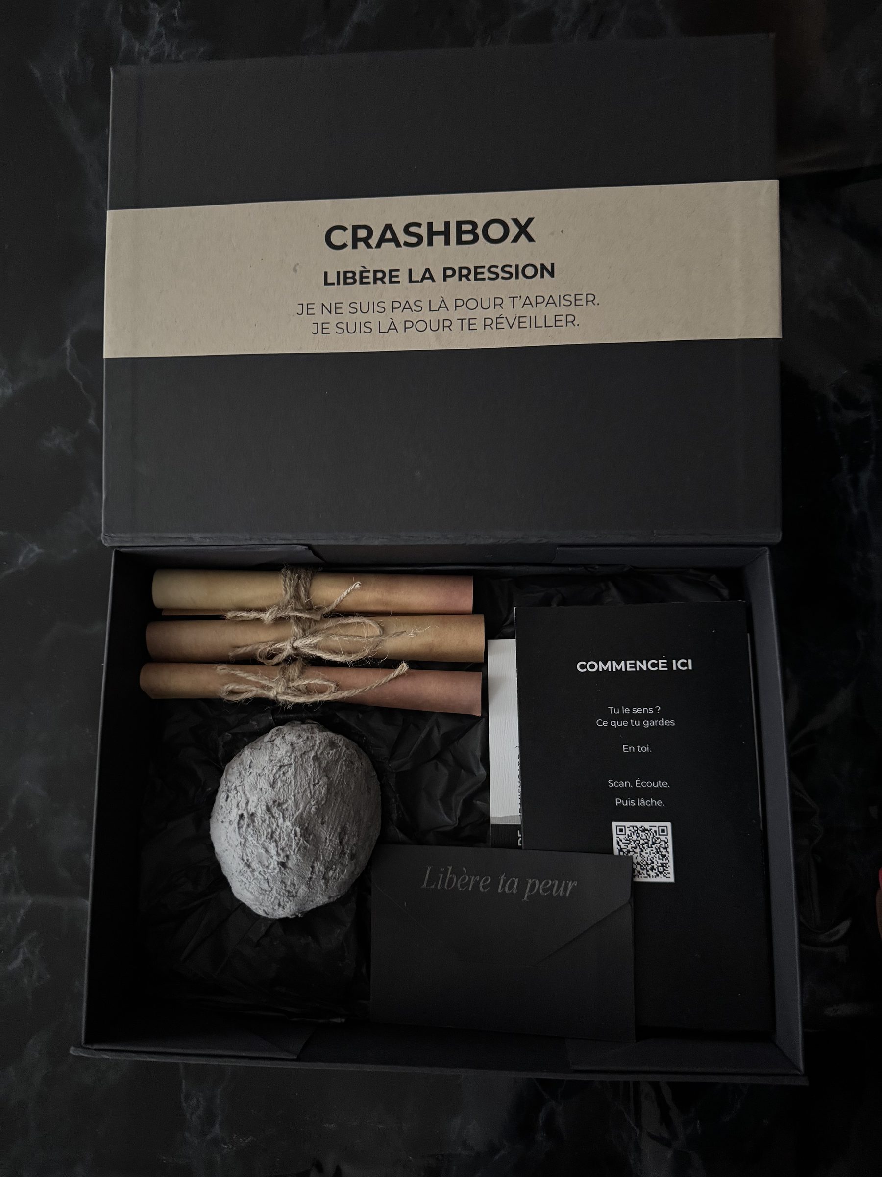 Main ouvrant la boîte CrashBox, contenu volontairement gardé mystérieux